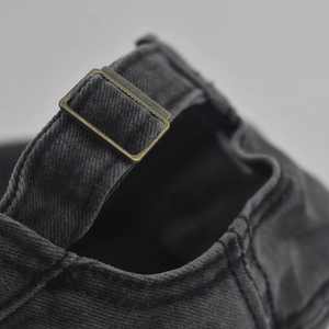 Detailed macro shot of vintage bronze metal buckle on washed grey military cap