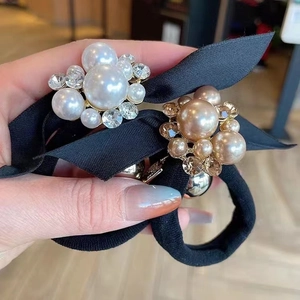 Detail of elegant pearl rhinestone hair ties with black satin bows and elastic bands