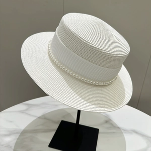 Detail of elegant white boater hat with pleated ribbon and pearl trim for women