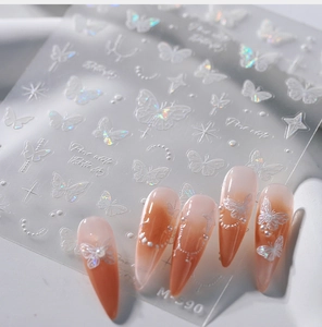Detailed relief of white 3D butterfly nail decals with holographic stars and pearls