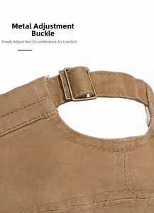 Detail of adjustable antique bronze metal buckle on washed cotton flat top cap