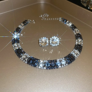 Close-up of luxury dark blue and clear zircon jewelry set on a gold tray