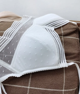 Detailed view of white mesh lace fabric with polka dot pattern on a wireless bra