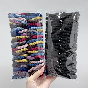 Macro shot of 50 elastic seamless hair ties in black and mixed colors packaging