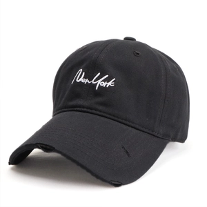 Close-up of New York embroidery and distressed frayed brim on black cotton baseball cap