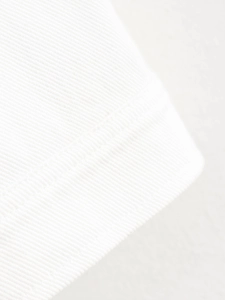 Close-up of white high-density twill cotton fabric with durable double-stitched edging