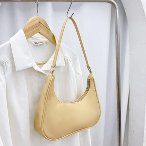 Minimalist nylon dumpling shoulder bag in creamy yellow with zipper and slim strap