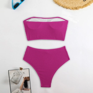 Detailed flat lay of fuchsia textured high-waisted bikini with bandeau top and summer props