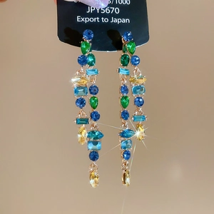 Detailed view of rhinestone waterdrop earrings with colorful tassels and silver needles