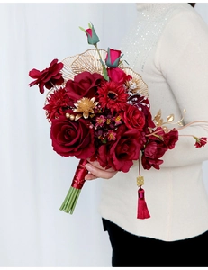Detail of red bridal bouquet with gold Xi character and silk tassels for Chinese weddings