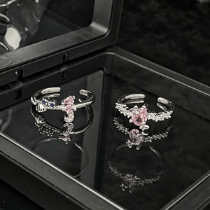 Macro shot of silver adjustable rings featuring pink zircon heart and seahorse charms