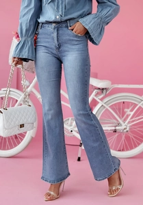 Détail de la texture d'un jean évasé bleu clair à taille haute et fini délavé
