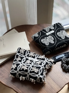 Detailed embroidery of butterflies and floral patterns on cotton linen makeup pouches