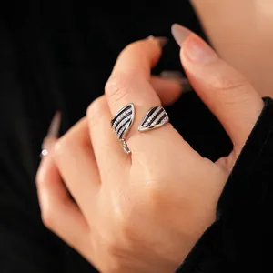 Vintage adjustable silver ring featuring black enamel wings and sparkling zircon pavé