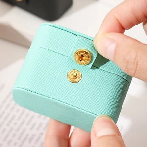 Close-up of mint green crossgrain leather jewelry box with golden snap closure detail