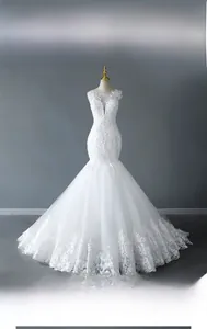 Detail of white mermaid wedding dress featuring lace appliques and V-neck sheer mesh