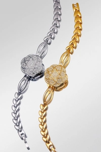 Detailed macro view of two camellia flower shaped watches with crystal leaf link bracelets