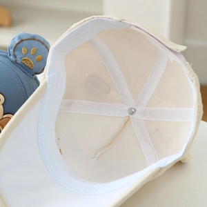 Detailed close-up of the breathable interior lining and bear ear stitching on the blue cap