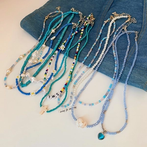 Detailed close-up of multilayered handmade pearl and colorful bead heart necklaces