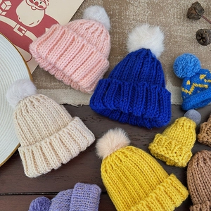 Colorful mini knitted Christmas hats with pom-poms for festive holiday decorations