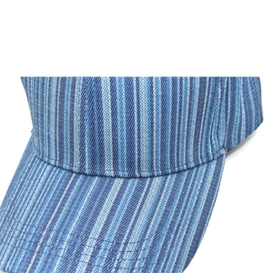Vue détaillée des rayures verticales bleues et blanches sur la texture du coton de la casquette
