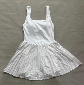 Detail shot of the white pleated tennis dress with an athletic racerback design