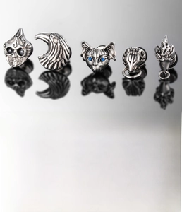 Detailed view of silver stainless steel gothic stud earrings with blue zircon feline design