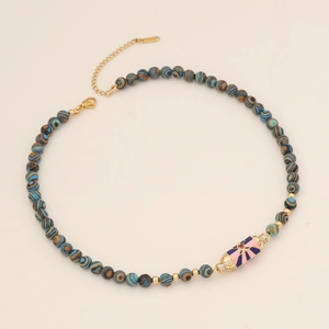 Detail of beaded necklace with blue striped stones and pink enamel evil eye pendant