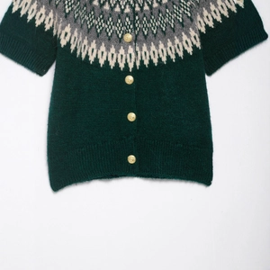 Dark green short sleeve Fair Isle knit cardigan with vintage gold buttons on white backdrop