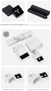 Detail view of drawer-style jewelry boxes in black and marble patterns with sponge inserts