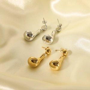 Elegant 18K gold-plated and silver chunky teardrop earrings on champagne silk background