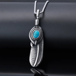Retro stainless steel feather pendant necklace with turquoise stone inlay on dark background