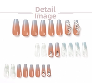 Detail of gradient press-on nails with 3D white flowers and silver butterfly accents