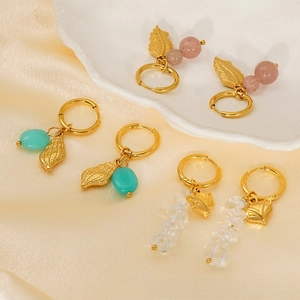 Détails de boucles d'oreilles dorées vintage avec pierre naturelle et breloques