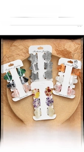 Close-up of shell-textured heart and star hair clips set on a white display card