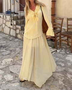 Detail of light yellow ruffle top and chiffon maxi skirt in an elegant resort style