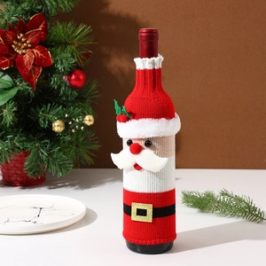Détail du cache-bouteille de vin tricoté Père Noël avec barbe blanche et bonnet rouge
