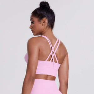 Detail of pink sports bra featuring cross-back straps and soft brushed elastic fabric