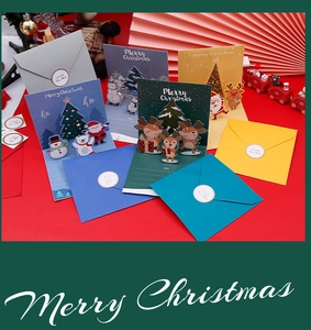 Close-up of 3D pop-up Christmas cards featuring Santa and reindeer with envelopes