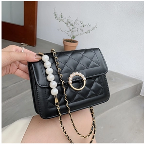 Detail view of the quilted leather bag with pearl ring and gold chain strap