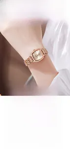 Détail de la montre carrée or rose avec bracelet en acier à cinq maillons et cadran épuré