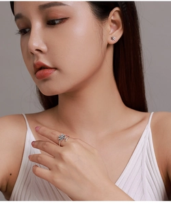 Close-up of model wearing silver S925 snowflake earrings and zircon open ring set