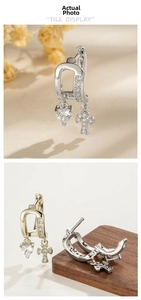 Close-up of heart-shaped zircon and cross pendants on metal hoop earrings set