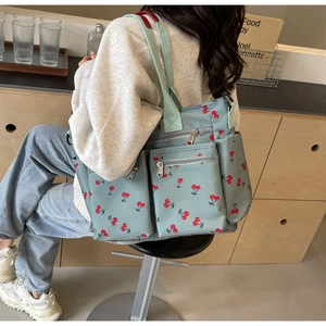 Detailed side view of light blue cherry print tote bag with large capacity pockets