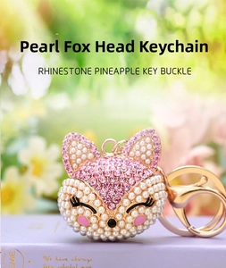 Detailed macro view of a pink rhinestone and pearl-encrusted fox head keychain charm