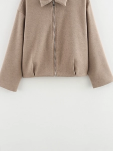 Détail de la texture polaire camel et de la fermeture éclair métallique de la veste