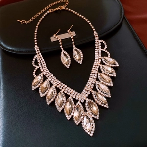 Macro shot of rose gold jewelry set with champagne marquise stones and white rhinestones