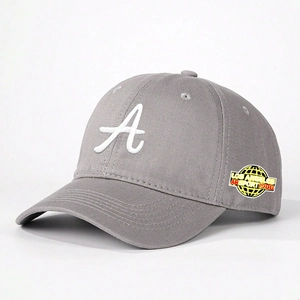 Détail de la casquette en sergé gris avec broderie A blanche et écusson latéral sport