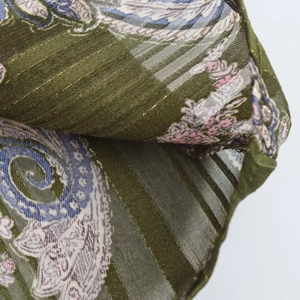 Detail of olive paisley fabric with gold metallic stripes and sheer floral chiffon texture