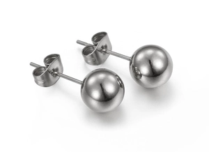 Macro view of polished silver ball stud earrings with butterfly backs on white base